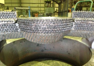 Cone crusher wear studs and hardfacing